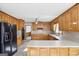 Spacious kitchen featuring wood cabinets, black appliances, and tile flooring at 2999 Happy Hollow Se Dr, Conyers, GA 30094