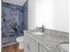 Bathroom with marble shower, wood floors, and a granite vanity with double sinks at 6274 Booker Ln, Lithonia, GA 30058