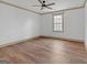 Bright bedroom with hardwood floors, large window, crown molding, and a ceiling fan at 6274 Booker Ln, Lithonia, GA 30058
