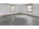 Large bedroom featuring wood floors, neutral trim, white walls, and two windows at 6274 Booker Ln, Lithonia, GA 30058