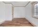 Bedroom with wood floors, neutral trim, white walls, and a window with natural light at 6274 Booker Ln, Lithonia, GA 30058