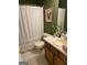 Charming bathroom features a shower with white curtain and a light wood vanity and cabinets at 200 Timber Ridge Dr, Mcdonough, GA 30252