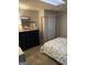 Bedroom with a floral patterned bedspread, dark dresser, and neutral carpet at 200 Timber Ridge Dr, Mcdonough, GA 30252