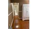 Hallway with hardwood floors leading to an open area with white decor at 200 Timber Ridge Dr, Mcdonough, GA 30252