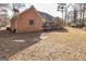 Back exterior view of a brick home with a covered deck and mature landscaping at 195 Youngs Cir, Fayetteville, GA 30215