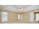 This is a view of the spacious main bedroom featuring multiple windows, neutral carpeting, and a ceiling fan at 195 Youngs Cir, Fayetteville, GA 30215