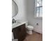 Powder room featuring a dark vanity, stone countertop, modern faucet, and round mirror at 130 Dockside Dr # 380, Fayetteville, GA 30215