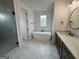 Bathroom showcasing a soaking tub, single vanity, and a glass shower with a view at 130 Dockside Dr # 380, Fayetteville, GA 30215