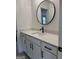 Bright bathroom featuring white cabinets and white stone countertops and round mirror at 130 Dockside Dr # 380, Fayetteville, GA 30215