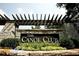 Stone entrance sign for 'The Canoe Club' surrounded by lush greenery and landscaping at 130 Dockside Dr # 380, Fayetteville, GA 30215