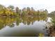 A serene lake view with fall foliage reflected in the calm water, creating a peaceful natural scene at 130 Dockside Dr # 380, Fayetteville, GA 30215