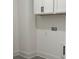 A well-lit laundry area with white cabinets and neutral walls showcasing the utility connections at 130 Dockside Dr # 380, Fayetteville, GA 30215