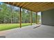 Covered patio offers a concrete floor and wood support beams facing a wooded lot at 130 Dockside Dr # 380, Fayetteville, GA 30215