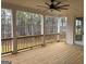 A covered patio with wood floors and a ceiling fan overlooks a wooded backyard at 130 Dockside Dr # 380, Fayetteville, GA 30215