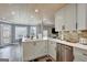Bright kitchen with stainless steel appliances, a large island, white cabinets, and an open view into the living spaces at 25 Grange Way, Sharpsburg, GA 30277