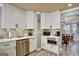 Updated kitchen features white cabinets, stainless steel appliances, and stylish brick backsplash at 25 Grange Way, Sharpsburg, GA 30277