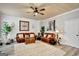 Bright living room featuring hardwood floors, leather sofas, and a ceiling fan at 25 Grange Way, Sharpsburg, GA 30277