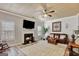 Cozy living room with shiplap wall, fireplace, ceiling fan, and comfortable leather sofas at 25 Grange Way, Sharpsburg, GA 30277