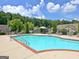 Community pool surrounded by mature trees, lounge chairs, and other amenities for relaxation at 430 Rehobeth Way, Fayetteville, GA 30214