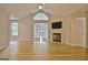 Bright living room with fireplace, high ceilings, hardwood floors, and French doors to sunroom at 430 Rehobeth Way, Fayetteville, GA 30214