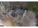 A high angle view of a brick home with well-kept landscaping and a large roof nestled in a wooded lot at 155 Glenwood Ln, Fayetteville, GA 30215