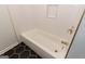 Modern bathroom featuring a clean white tub, unique tile flooring, and sleek fixtures, perfect for relaxation at 155 Glenwood Ln, Fayetteville, GA 30215
