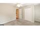 Comfortable carpeted bedroom features a ceiling fan, closet, and an open doorway to another room at 155 Glenwood Ln, Fayetteville, GA 30215