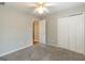 Comfortable carpeted bedroom featuring a ceiling fan and closet provides a tranquil retreat at 155 Glenwood Ln, Fayetteville, GA 30215