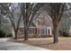 Charming brick home features a traditional design with a black front door and black shutters, and established trees at 155 Glenwood Ln, Fayetteville, GA 30215