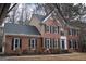 Traditional brick two-story home with black shutters, complemented by mature trees and landscaping at 155 Glenwood Ln, Fayetteville, GA 30215