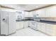 Charming kitchen featuring white cabinets, appliances, a window, and tile flooring at 155 Glenwood Ln, Fayetteville, GA 30215
