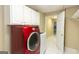 Laundry room featuring red and white appliances, tile floors, and access to a hallway at 155 Glenwood Ln, Fayetteville, GA 30215