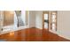 Living room view with hardwood floors, white walls, fireplace in the adjacent room, and doors separating it from the foyer at 155 Glenwood Ln, Fayetteville, GA 30215