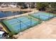 Aerial view of four well-maintained, blue and green, community tennis courts at 155 Glenwood Ln, Fayetteville, GA 30215
