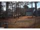 Spacious backyard featuring a lush lawn, mature trees, and a view of the home's back exterior, enclosed by a chain-link fence at 3281 Nina Way, Douglasville, GA 30135