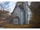 Two-story home featuring a classic blue exterior, complemented by a dark roof, surrounded by mature trees and a well-kept yard at 3281 Nina Way, Douglasville, GA 30135