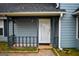 Charming entryway with a white door and a covered porch featuring painted blue siding and a welcome mat at 3281 Nina Way, Douglasville, GA 30135