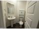 Small bathroom with pedestal sink, decorative mirror and cabinet above toilet at 142 Hampton Cir, Mcdonough, GA 30253