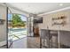 This stylish basement bar features brick accent wall, stainless steel bar, and access to the pool at 2242 Sxxxx Xxxx Rd, Buford, GA 30518