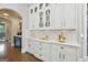 Elegant butler's pantry featuring white cabinetry, marble countertops, and decorative glass-front cabinets at 2242 Sxxxx Xxxx Rd, Buford, GA 30518