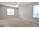 Spacious bedroom with neutral carpet, two windows, and a ceiling fan at 120 Fen Way, Peachtree City, GA 30269