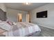 Relaxing bedroom featuring plush carpet, a gray tufted headboard, and TV at 5540 Wood Falls Dr, Buford, GA 30518