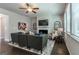 Living room featuring a fireplace, TV, ceiling fan, and a large grey sofa with windows at 113 Maplewood Ln # 176, Conyers, GA 30094