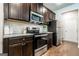Modern kitchen with stainless steel appliances, dark cabinets, granite countertops, and white subway tile at 113 Maplewood Ln # 176, Conyers, GA 30094