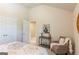 Bright bedroom with a view into the hallway, showcasing a side table, chair, and double door closet at 113 Maplewood Ln # 176, Conyers, GA 30094