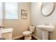 Powder room featuring a pedestal sink, oval mirror, and window offering natural light at 113 Maplewood Ln # 176, Conyers, GA 30094