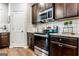 Modern kitchen with stainless steel appliances, dark cabinets, granite countertops, and white subway tile backsplash at 113 Maplewood Ln # 176, Conyers, GA 30094