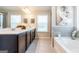 Bathroom featuring a double vanity, soaking tub, separate shower, and natural light at 113 Maplewood Ln # 176, Conyers, GA 30094