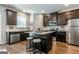 Kitchen with island, stainless steel appliances, dark cabinets, granite countertops, and stools at 113 Maplewood Ln # 176, Conyers, GA 30094