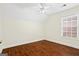 This bedroom features wood floors, a ceiling fan, and natural light from the window at 243 Long Dr, Mcdonough, GA 30253